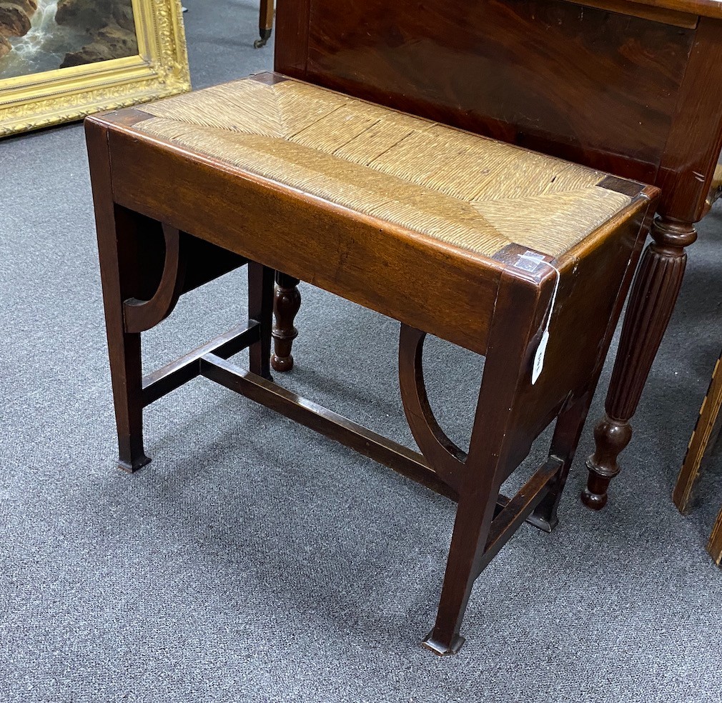 An Arts & Crafts mahogany stool with drop in rush seat, width 61cm, depth 34cm, height 53cm.